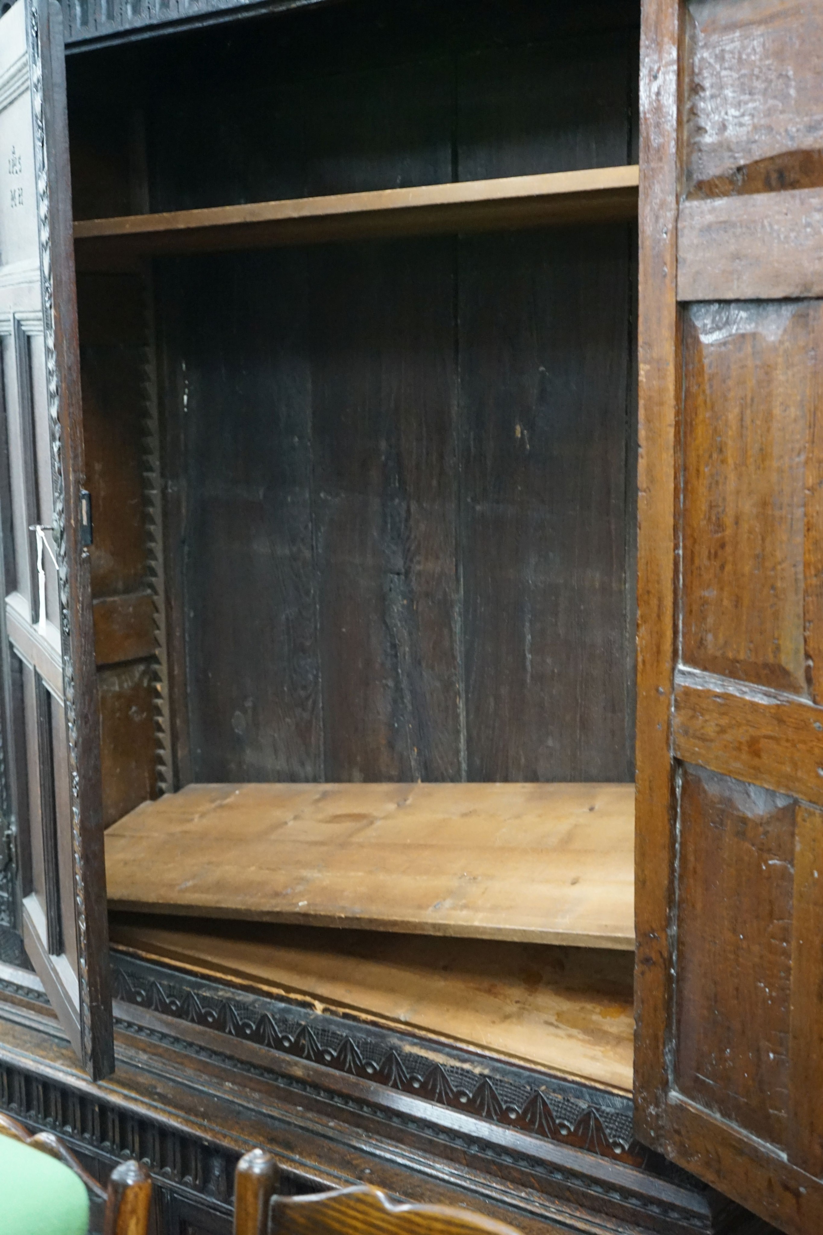 A carved oak cupboard, enclosed by panelled doors, bearing monograms and dated 1601, width 138cm, depth 53cm, height 218cm